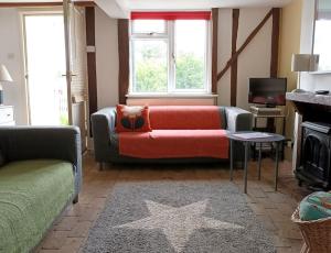 a living room with a couch and a star rug at Period Cottage near Suffolk Coast and Forest in Tunstall