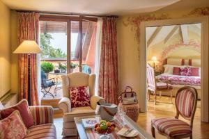 a living room with a large mirror and a bedroom at L'Albereta Relais & Chateaux in Erbusco