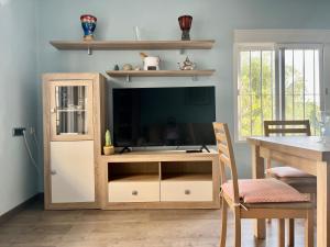 a living room with a entertainment center with a television at Luz y brisa in Oropesa del Mar