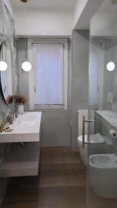 uma casa de banho com 2 lavatórios, um WC e uma janela em Buongiorno al Vaticano em Roma
