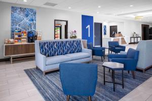 a waiting room with a couch and blue chairs at Holiday Inn Express Hotel & Suites Hermosa Beach by IHG in Hermosa Beach +97 photos