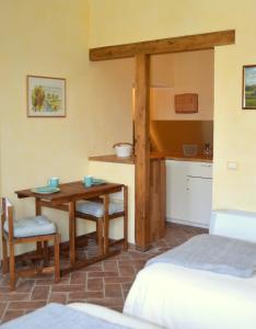 バジーリオにあるAgriturismo Borgo San Francescoのテーブルとベッド1台付きの部屋、キッチンが備わるアパートメントです。