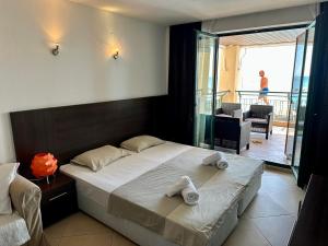 1 dormitorio con 1 cama con toallas en Home Sweet Home Black Sea View en Balchik