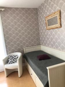 a small bedroom with a bed and a chair at Appartement bagnoles in Bagnoles de l'Orne