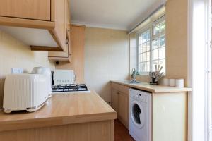 a kitchen with a washer and dryer on a counter at The Morden Room in London