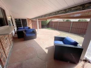 un patio con 2 sillas y un sofá en el patio en In the heart of Plano complete remodel home, en Plano