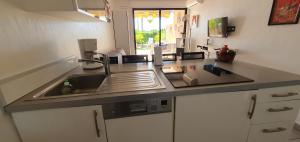 - une cuisine avec un évier et un comptoir dans l'établissement Residence Egee, à Cannes