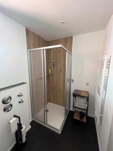 a bathroom with a shower with a wooden wall at Altstadtwohnung - Old Town in Trostberg an der Alz