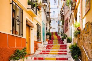an alley with colorful stairs in an old town at Apartamento MARCO a 250m playa in Calpe
