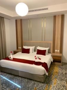 ein Schlafzimmer mit einem großen Bett mit roten Kissen in der Unterkunft GOLDEN NEW UMU ALQURAA Hotel in Dschidda