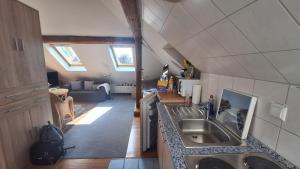 a kitchen with a sink and a living room at Ferienwohnung Tölle in Bad Rehburg