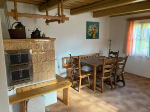 Chalupa U Měšťanů في Lužná: غرفة طعام مع طاولة وكراسي خشبية