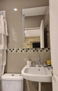 a bathroom with a sink and a toilet and a mirror at Dpto Los Medanos in Puerto Madryn