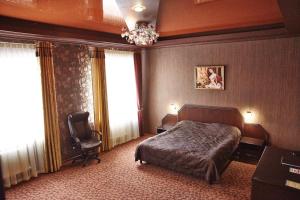 マグニトゴルスクにあるRusskaya Usadbaのベッドルーム1室(ベッド1台、椅子、窓付)