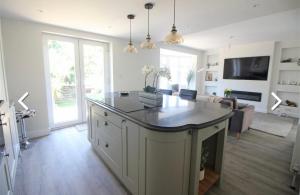 a kitchen with an island in the middle of a living room at Kinghurst Lodge 5 minutes from the sea in Torquay