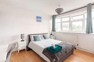 a white bedroom with a bed and a window at Spacious Room by Lee Valley White Water Centre. Waltham Cross in Waltham Cross
