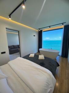 a bedroom with a large bed and a bath tub at Black Diamond Sevan in Sevan
