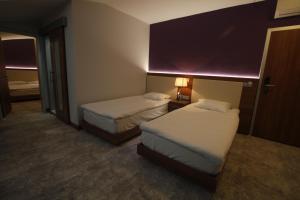 a hotel room with two beds and a lamp at Business Palas Otel in Kocaeli