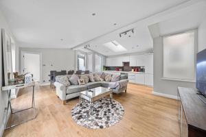 a living room with a couch and a table at Captivating 3-Bed House in London Holland Park in London