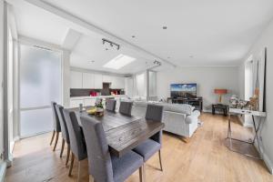 a dining room and living room with a table and chairs at Captivating 3-Bed House in London Holland Park in London