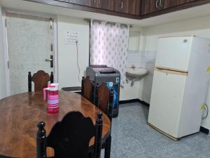 a kitchen with a table and a refrigerator at Happy Home in Coimbatore