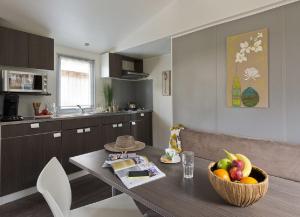 una cocina con una mesa con un bol de fruta. en Mobil Homes Vacances en Grimaud