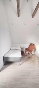 Villa Vandkant في Thyholm: غرفة بيضاء بسرير وكرسي