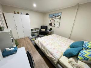 1 dormitorio con cama, escritorio y silla en Comfortable homestay, en Clayton North