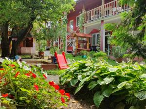 a garden with red flowers and a red swing at Apartmány Viola in Štúrovo
