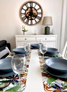 ein Esszimmer mit einem Tisch mit Tellern und Weingläsern in der Unterkunft Apartamento Luz de Conil. WIFI+A/C. SOLO FAMILIAS Y PAREJAS in Conil de la Frontera