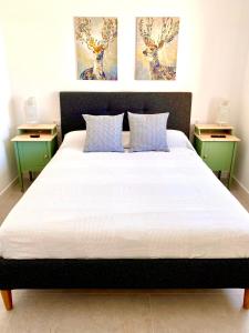 um quarto com uma cama grande e 2 mesas de cabeceira em Apartamento Luz de Conil. WIFI+A/C. SOLO FAMILIAS Y PAREJAS em Conil de la Frontera