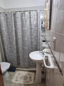 a bathroom with a shower curtain and a sink at Home in Río Cuarto +10 photos