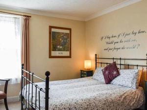 a bedroom with a bed with a quote on the wall at Two rivers reach in Iford