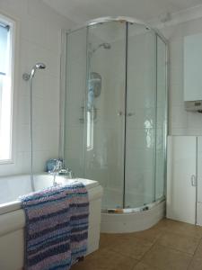 a bathroom with a shower and a tub and a sink at Two rivers reach in Iford