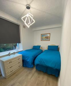 a bedroom with two beds and a large window at Two rivers reach in Iford