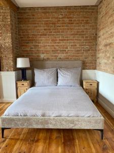 a bed in a room with a brick wall at Apartments PSD - Wojska Polskiego 5 in Słupsk