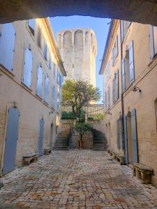 a stone alley with a castle in the background at La DAME de FLAUX in Uzès