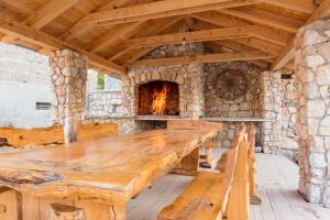 a large wooden table in front of a stone oven at Villa Stone Valcer in Slivno