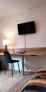 a room with a desk with a television and a chair at Zur Elster 1 in Plauen