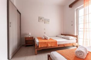 a bedroom with two beds and a window at Mike's Apartments in Nei Poroi