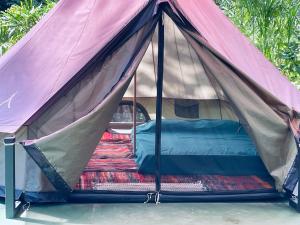 a canopy tent with a bed in it at Glamping Uvita River in Uvita