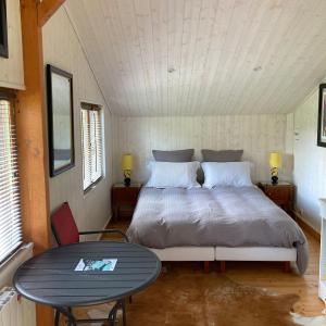 a bedroom with a bed and a table in it at Domaine des Thyllères,Chalet Colvert in Beaufour