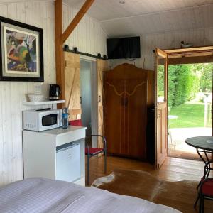 1 dormitorio con 1 cama y microondas en la encimera en Domaine des Thyllères,Chalet Colvert, en Beaufour