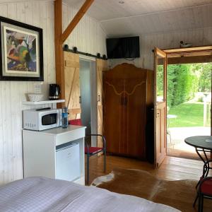 a bedroom with a bed and a microwave on a counter at Domaine des Thyllères,Chalet Colvert in Beaufour