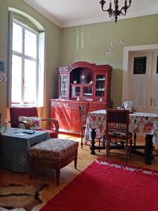 uma sala de estar com um armário vermelho e cadeiras em Apartmani Dragulj em Kula