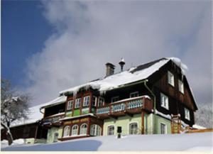 a large building with snow on top of it at Bunzbauernhof in Bad Mitterndorf