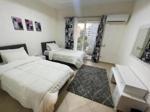 pokój hotelowy z 2 łóżkami i oknem w obiekcie شقة للايجار كمبوند زايد ديونز w mieście Sheikh Zayed