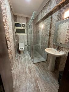 La salle de bains est pourvue de toilettes, d'un lavabo et d'une douche. dans l'établissement شقة للايجار كمبوند زايد ديونز, à Sheikh Zayed