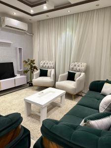 a living room with two couches and a tv at شقة للايجار كمبوند زايد ديونز in Sheikh Zayed