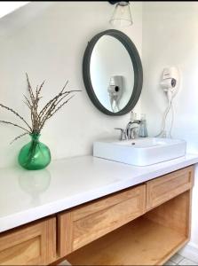 a bathroom with a white sink and a mirror at Groundswell Pub & Inn in DʼEscousse